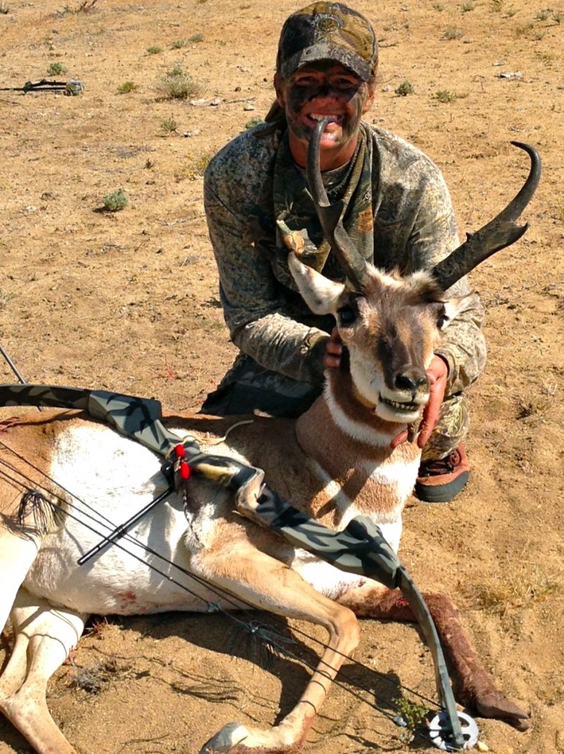Female hunter posing with her bow and trophy antelope