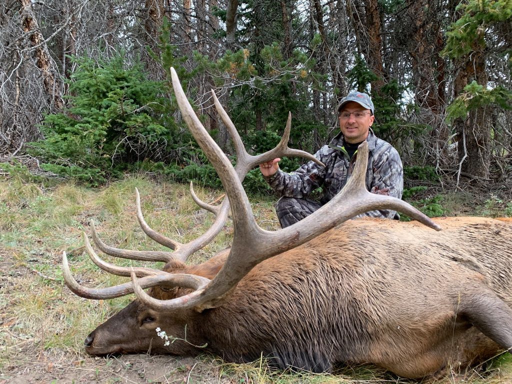 A hunter and his trophy bull elk taken on our wilderness pack-in hunt