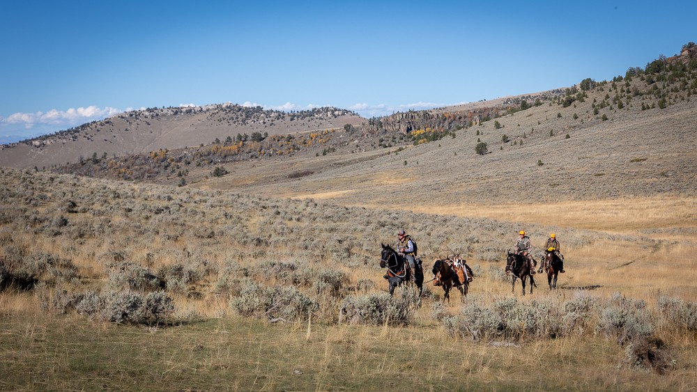 hunters riding across the mountain landscape of high country Wyomings