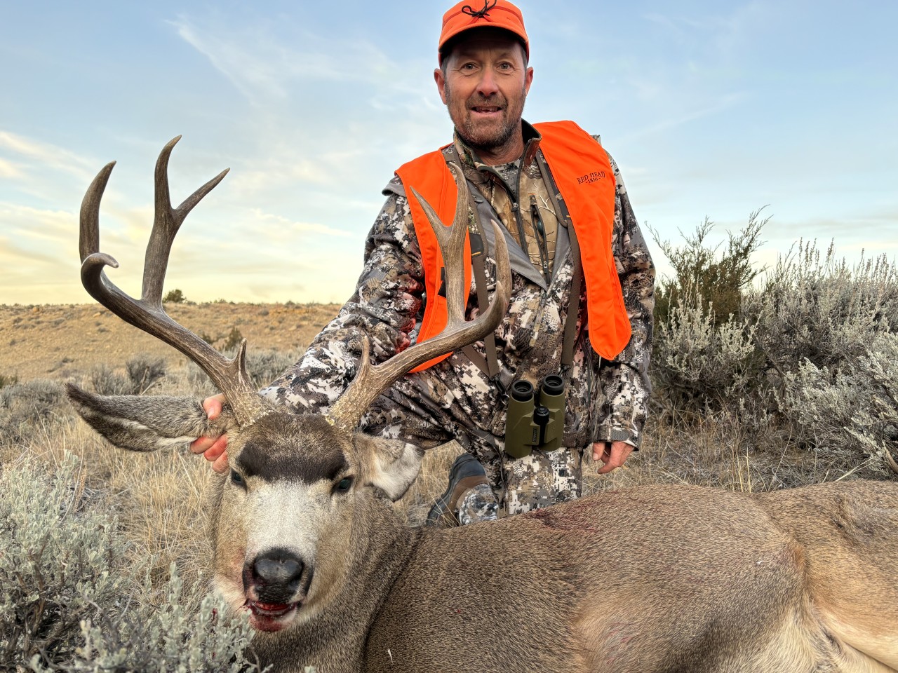 A hunter poses with a large mule deer buck in Montana