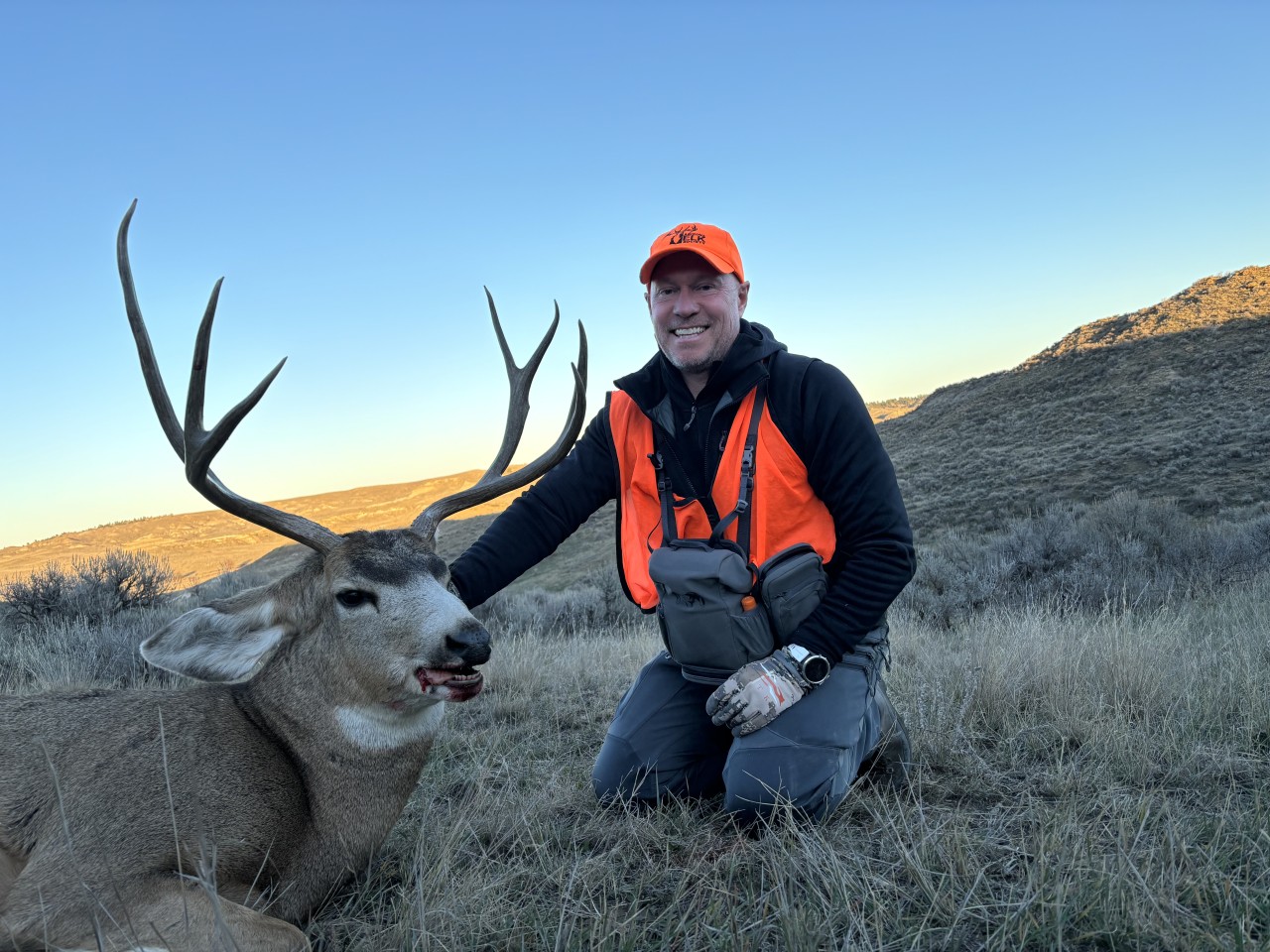 A hunter poses with a large mule deer buck in Montana