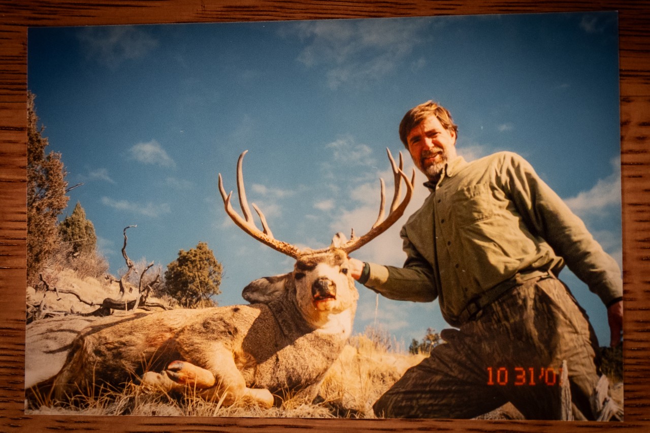 hunter poses with a large mule deer buck in Wyoming
