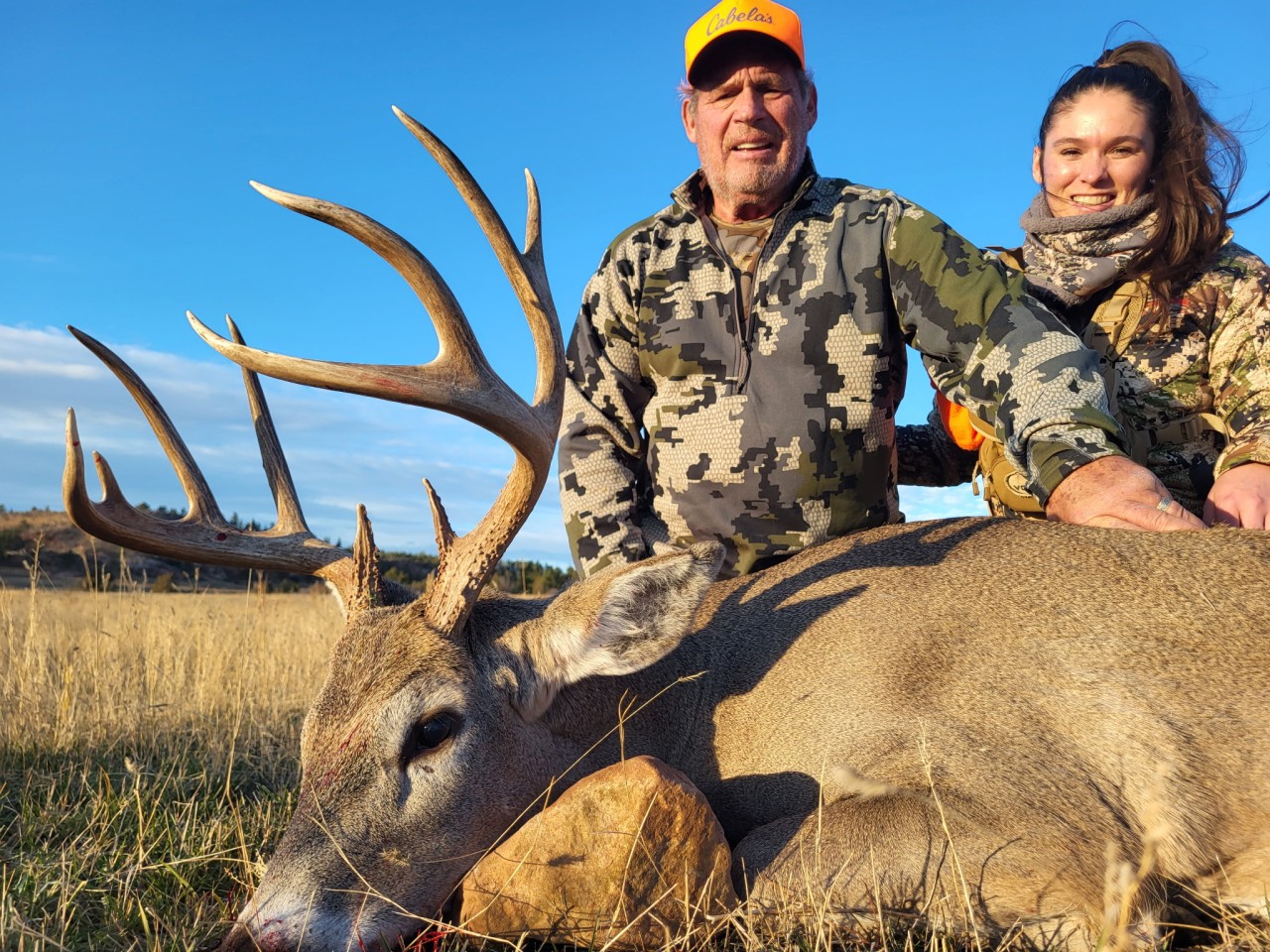hunter poses with a large whitetail deer buck in Wyoming